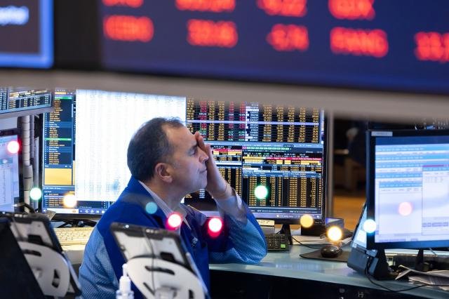 A trader at his computer terminal as news of the Federal Reserve rate cut decision are show on TV at the New York Stock Exchange in New York New York USA 18 December 2024 մ