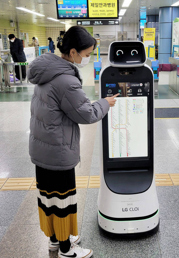LG전자 안내로봇인 'LG 클로이 가이드봇'이 대구도시철도 1호선 상인역에서 고객들을 맞이하고, 지하철 관련 정보와 역사 내 주요시설을 안내한다. 사진은 지하철을 이용하는 시민이 LG 클로이 가이드봇을 통해 노선도를 확인하고 있는 모습. /LG전자