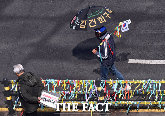 지난 3일 서울 종로구 헌법재판소 인근 도로에서 윤 대통령 탄핵을 촉구하는 시민들이 구호가 적힌 우산, 피켓 등을 들고 시위에 참여하기 위해 이동하고 있다. /이새롬 기자
