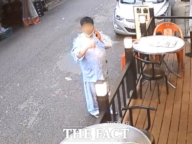 서울 강북구 서울 지하철 4호선 미아역 인근의 한 마트에서 환자복 차림의 30대 남성이 지난 22일 오후 6시20분께 '묻지마 칼부림' 난동을 벌인 후 식당 앞에서 담배를 피고 있다./독자제공